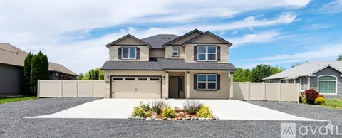 A modern house with a large front yard and a driveway.