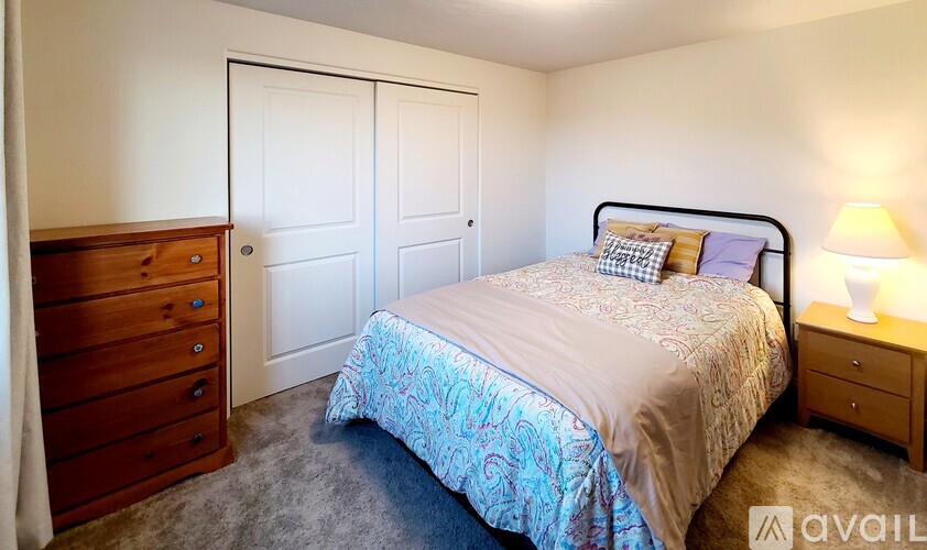 A bedroom with a bed, dresser, and nightstand.