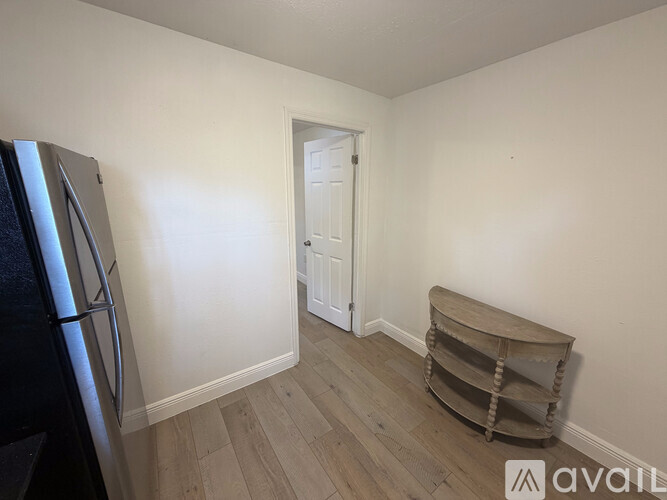 A kitchen with a fridge and a wooden barrel stool.