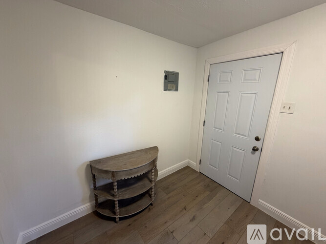 A room with a white door and a wooden table.