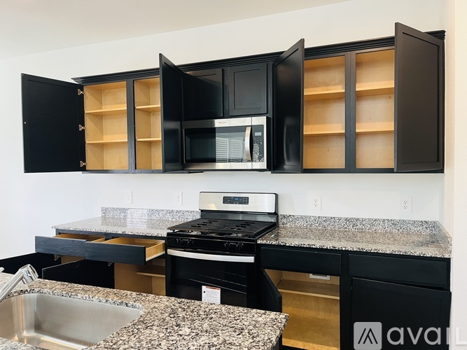 A kitchen with black cabinets and a granite countertop.