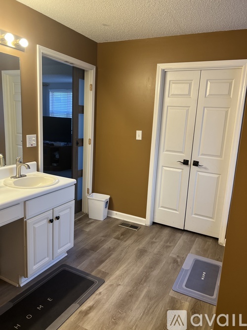 A bathroom with brown walls and a white door.