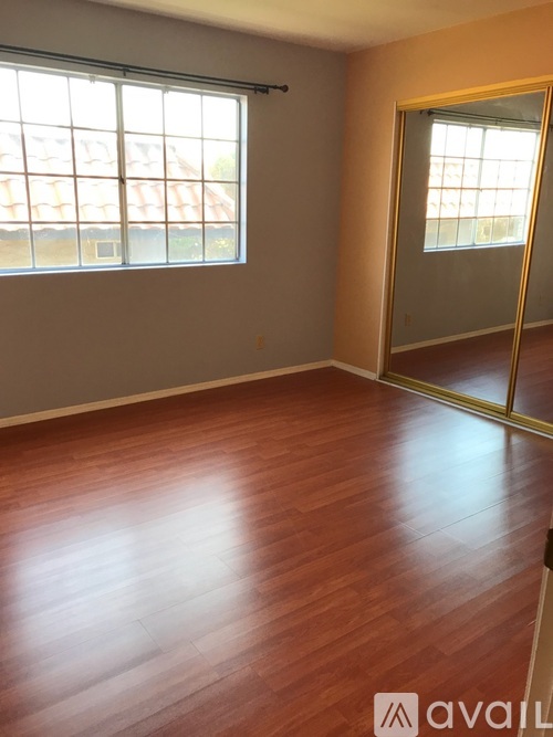 A room with wooden flooring and a sliding glass door.