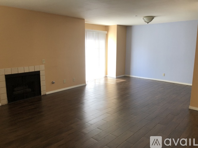 A living room with a fireplace and wood flooring.