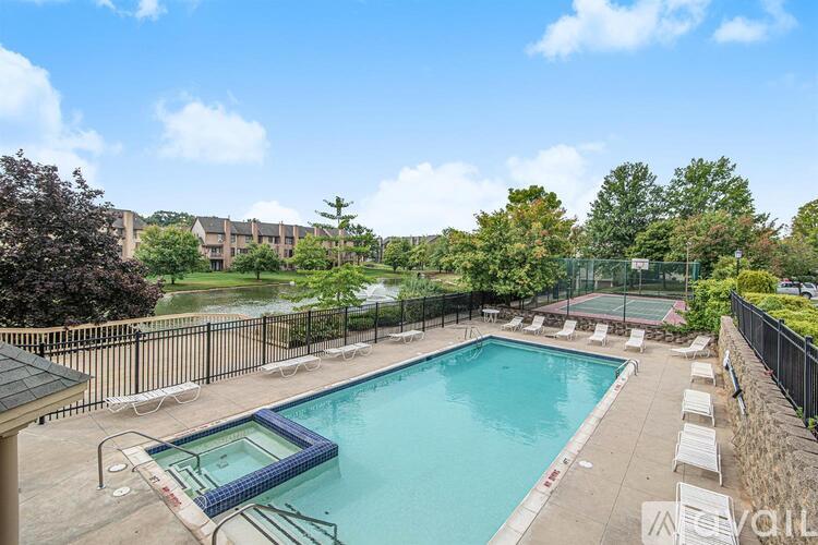 A pool surrounded by a fence and trees.