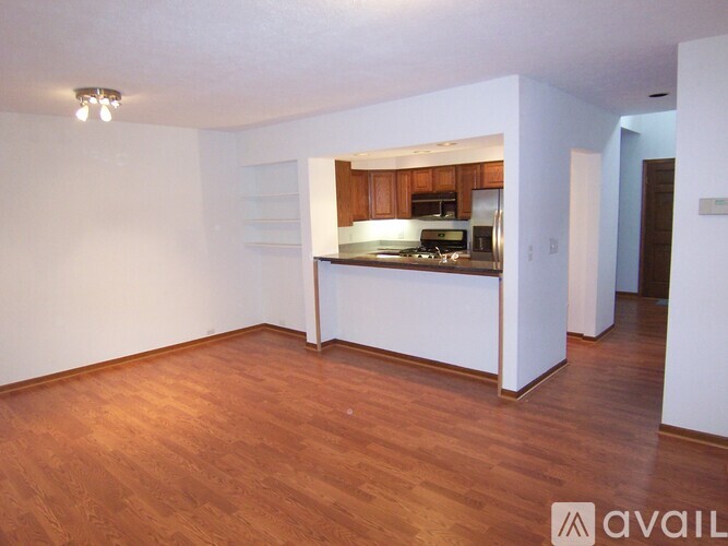 A kitchen area with wooden floors and white walls.