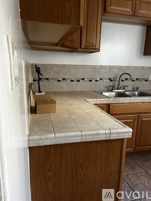 A kitchen with wooden cabinets and a marble countertop.