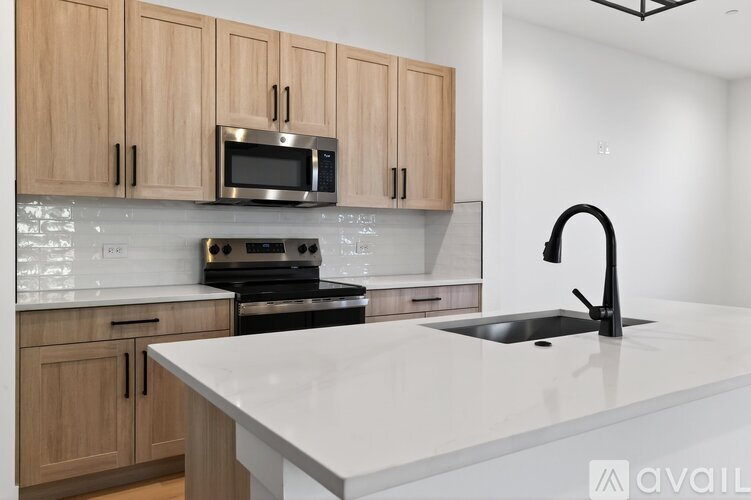 A modern kitchen with wooden cabinets and a white countertop.
