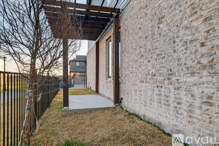 A house with a stone wall and a metal fence.