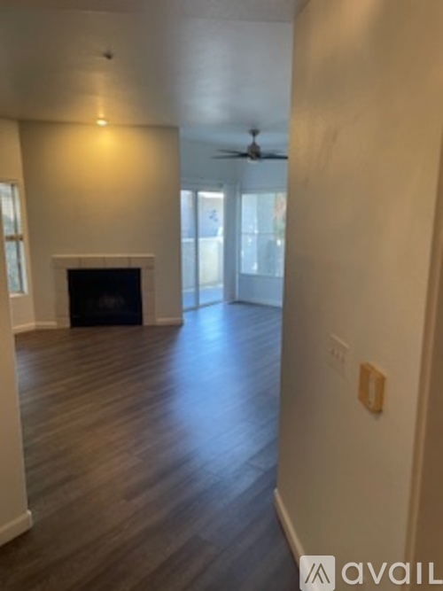 A spacious room with a fireplace and a ceiling fan.