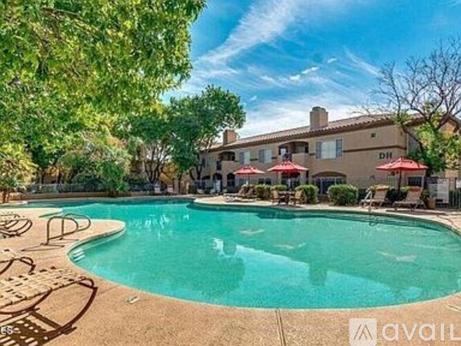 A pool surrounded by trees and chairs with a house in the background.