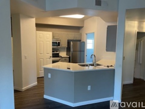 A kitchen with a sink and a refrigerator.