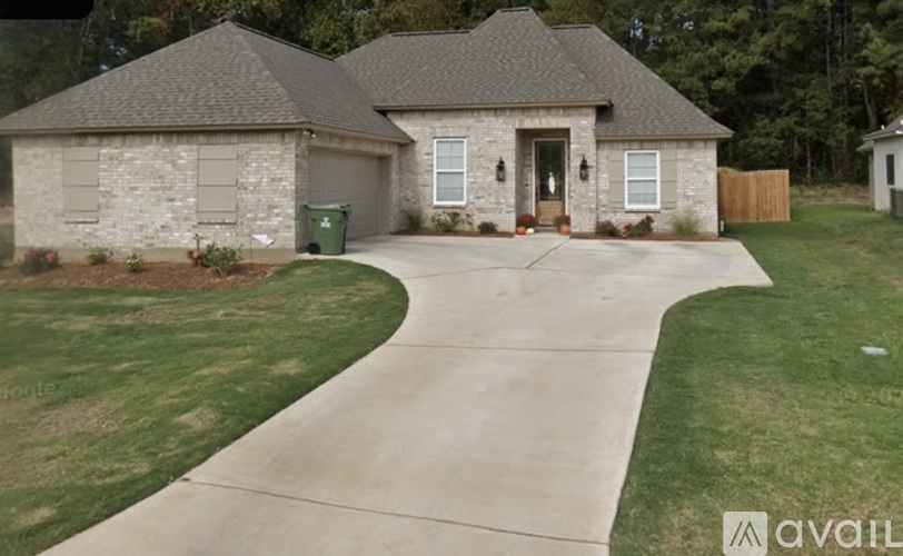 A house with a grey roof and a driveway in front.