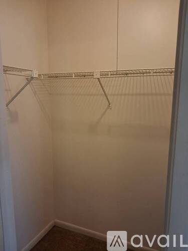 A small, empty closet with a white door and a white wall.