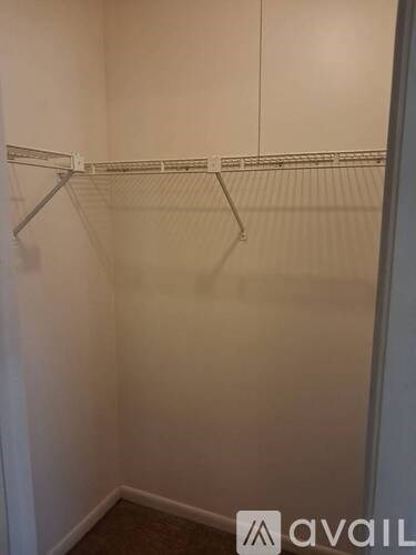 A small, empty closet with a white door and a white wall.