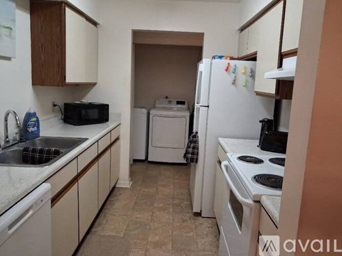 A kitchen with white appliances and a washing machine.