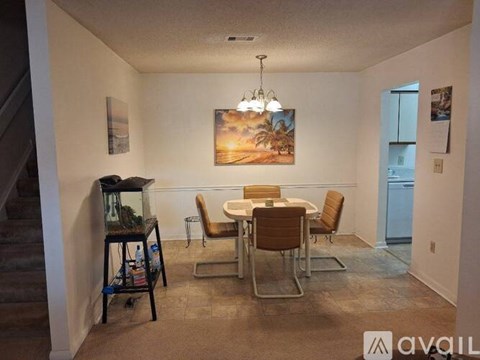 A dining room with a table and chairs and a fish tank.