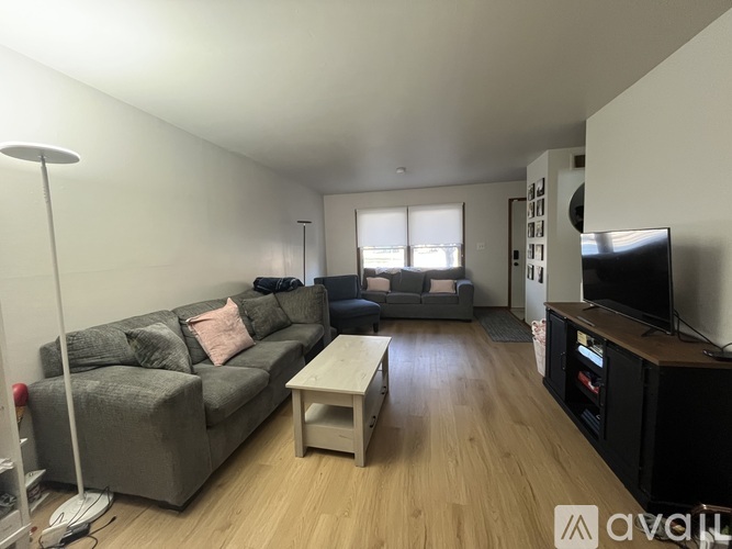 A living room with a grey couch and a white coffee table.