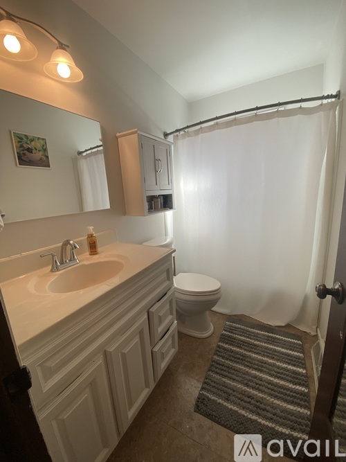 A bathroom with a sink, toilet, and shower.