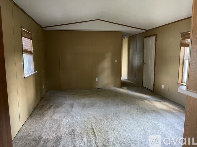 A room with a carpeted floor and wooden walls.