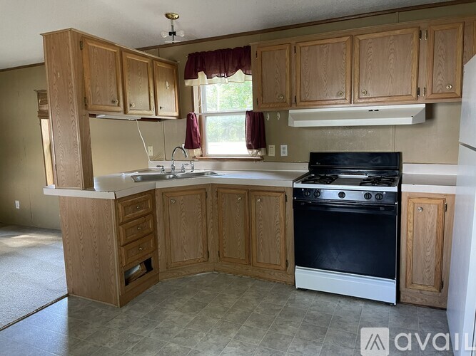 A kitchen with wooden cabinets and a black stove top oven.