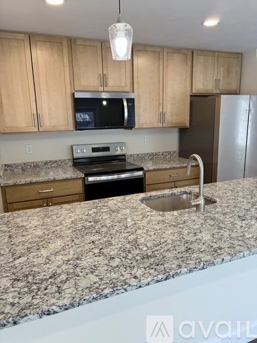 A kitchen with granite countertops and wooden cabinets.