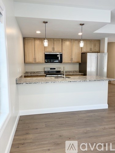 A kitchen with wooden cabinets and a granite countertop.