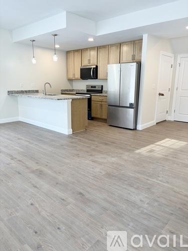A kitchen with wooden cabinets and a refrigerator.