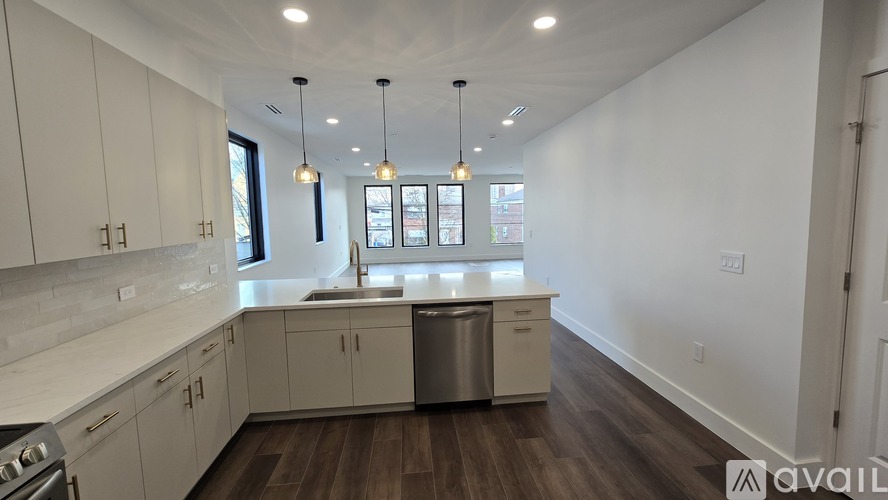 A kitchen with white cabinets and a wooden floor.