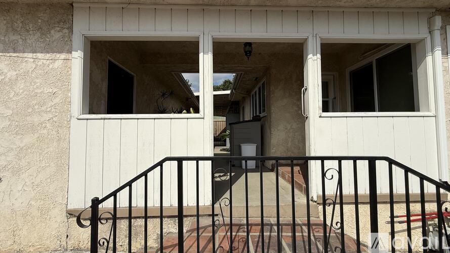 A white house with a black railing and a small balcony.