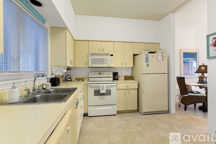 A kitchen with a sink, stove, and refrigerator.