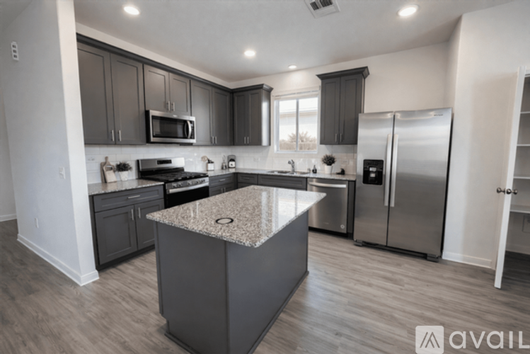 A kitchen with a granite countertop and stainless steel appliances.