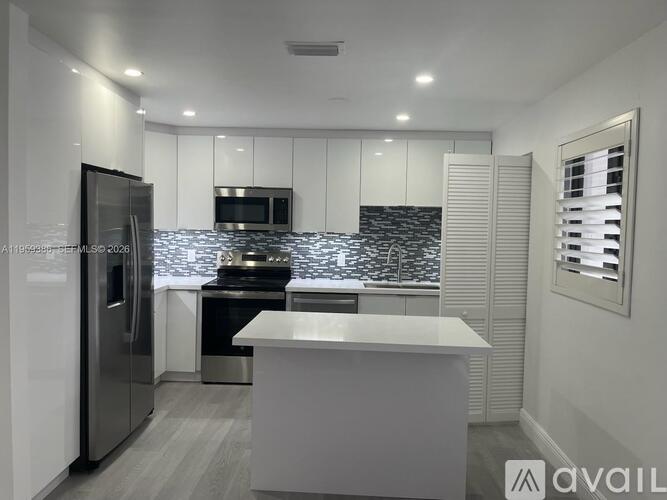 A modern kitchen with a refrigerator, stove, and countertop.