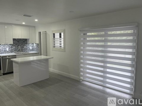 A modern kitchen with white cabinets and a large island.