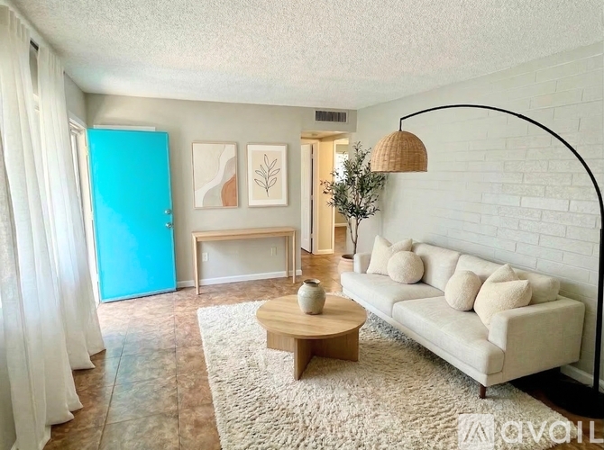 A living room with a white couch, a wooden coffee table, and a white rug.