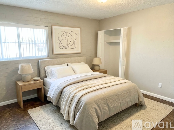A bedroom with a bed, nightstand, and lamp.