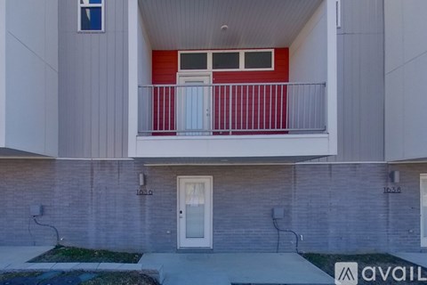 A building with a red balcony and a white door.