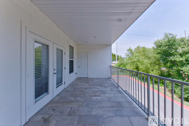 A balcony with a metal railing and tiled floor.