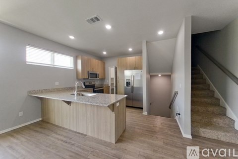 A kitchen with a granite countertop and stainless steel appliances.
