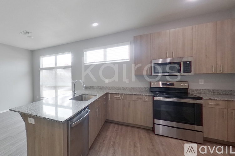 A kitchen with wooden cabinets and stainless steel appliances is available for rent.