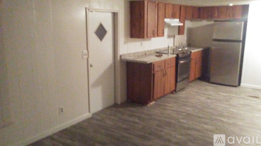 A kitchen with wooden cabinets and a refrigerator.