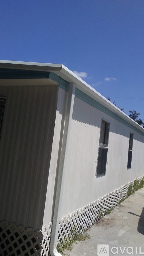 A white building with a black fence in front.