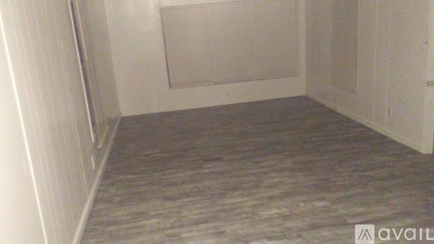 A room with a grey carpet and white walls.