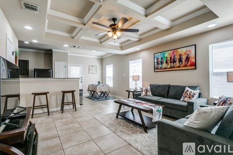 A living room with a bar area and a painting on the wall.
