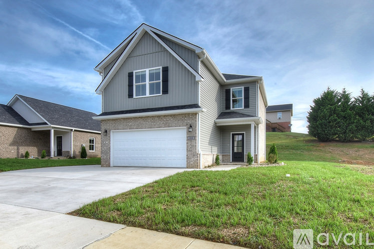 A two-story house with a garage is available for sale.