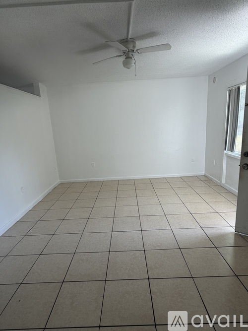 A room with a ceiling fan and tiled floor.