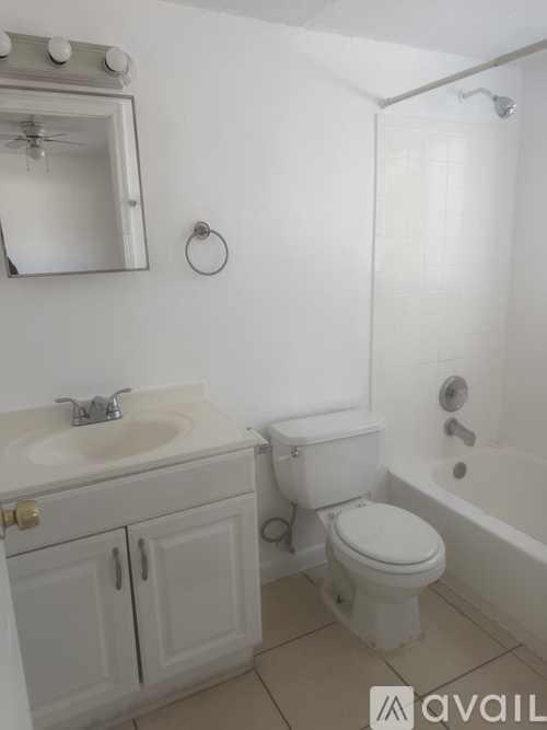 A white bathroom with a toilet, sink, and tub.