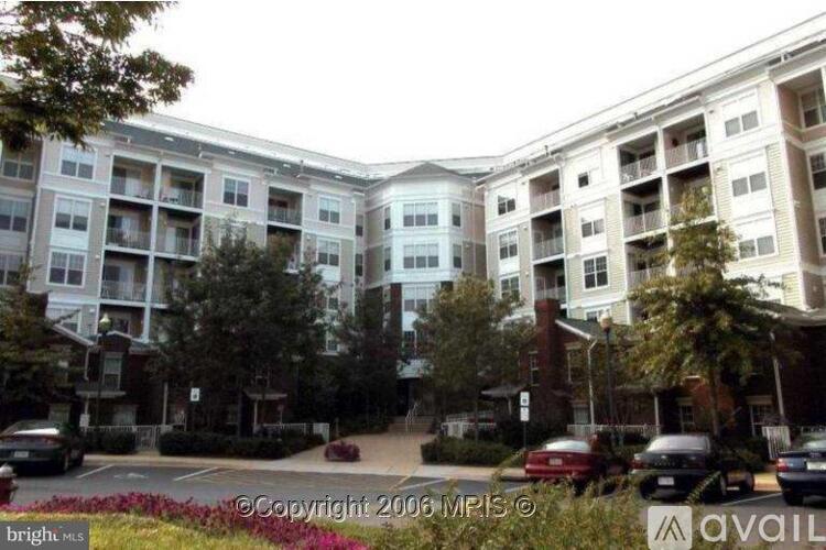 A large apartment complex with multiple buildings and cars parked in front.