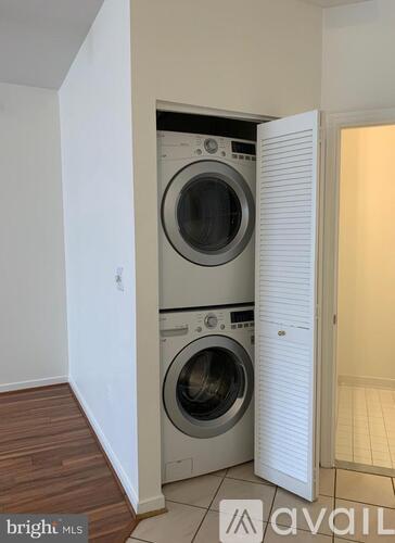 A washer and dryer are built into a wall in a small room.
