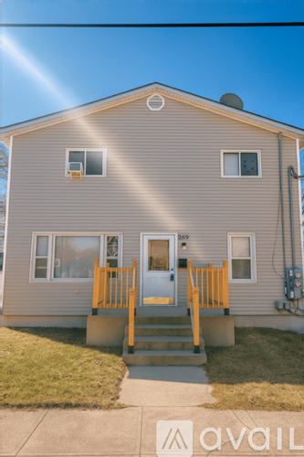 A house with a grey siding and a yellow door.